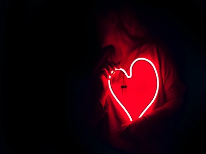 woman holding neon light heart